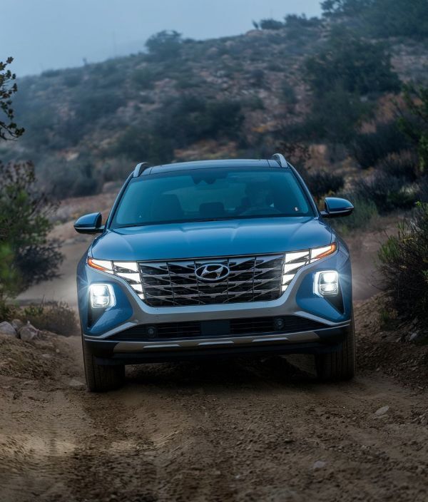 a-2025-hyundai-tuscon-blue-on-a-hilly-dirt-road-after-Hyundai-Certified-Body-Shop-Repair